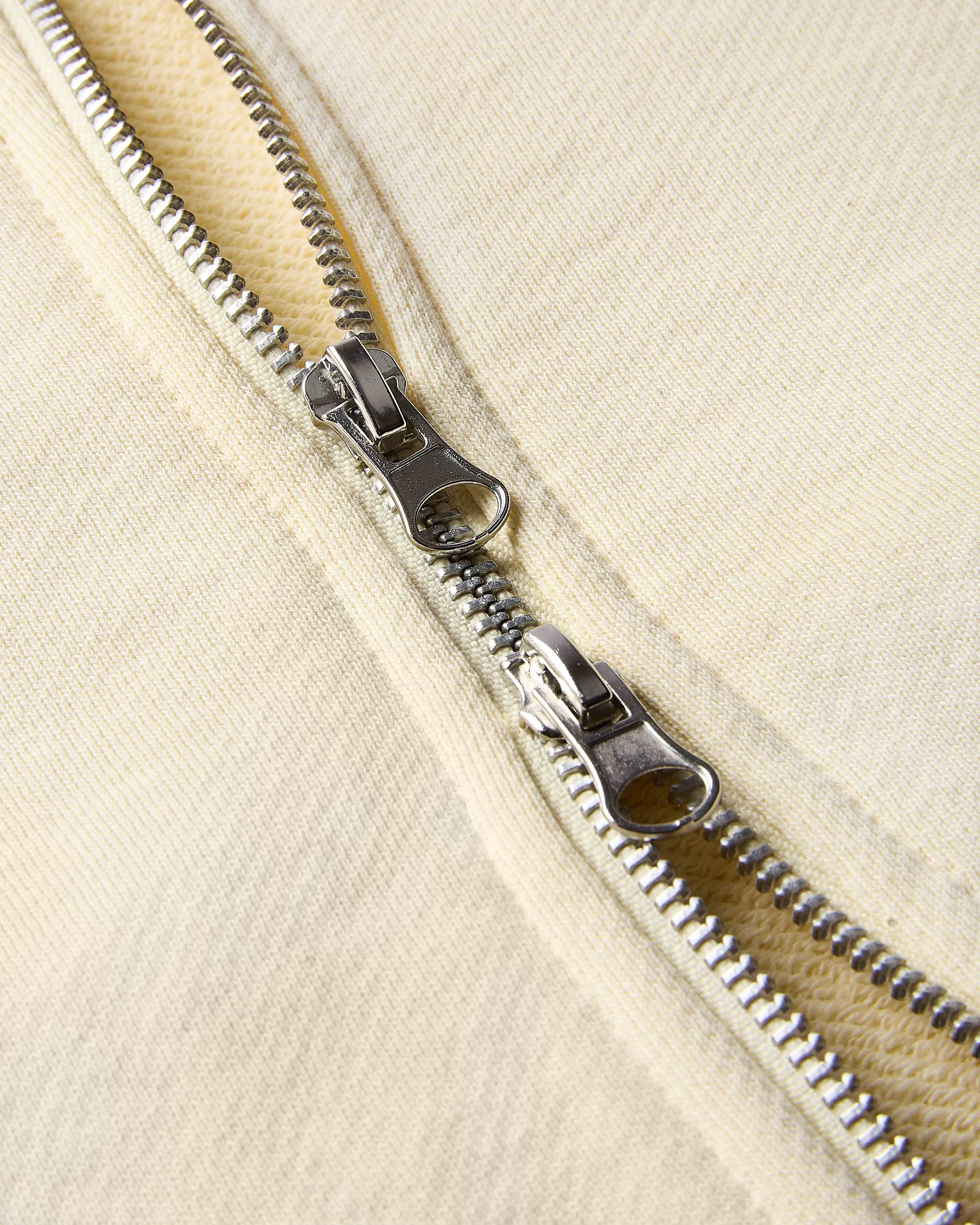 Close-up of a zipper on a beige fabric background
