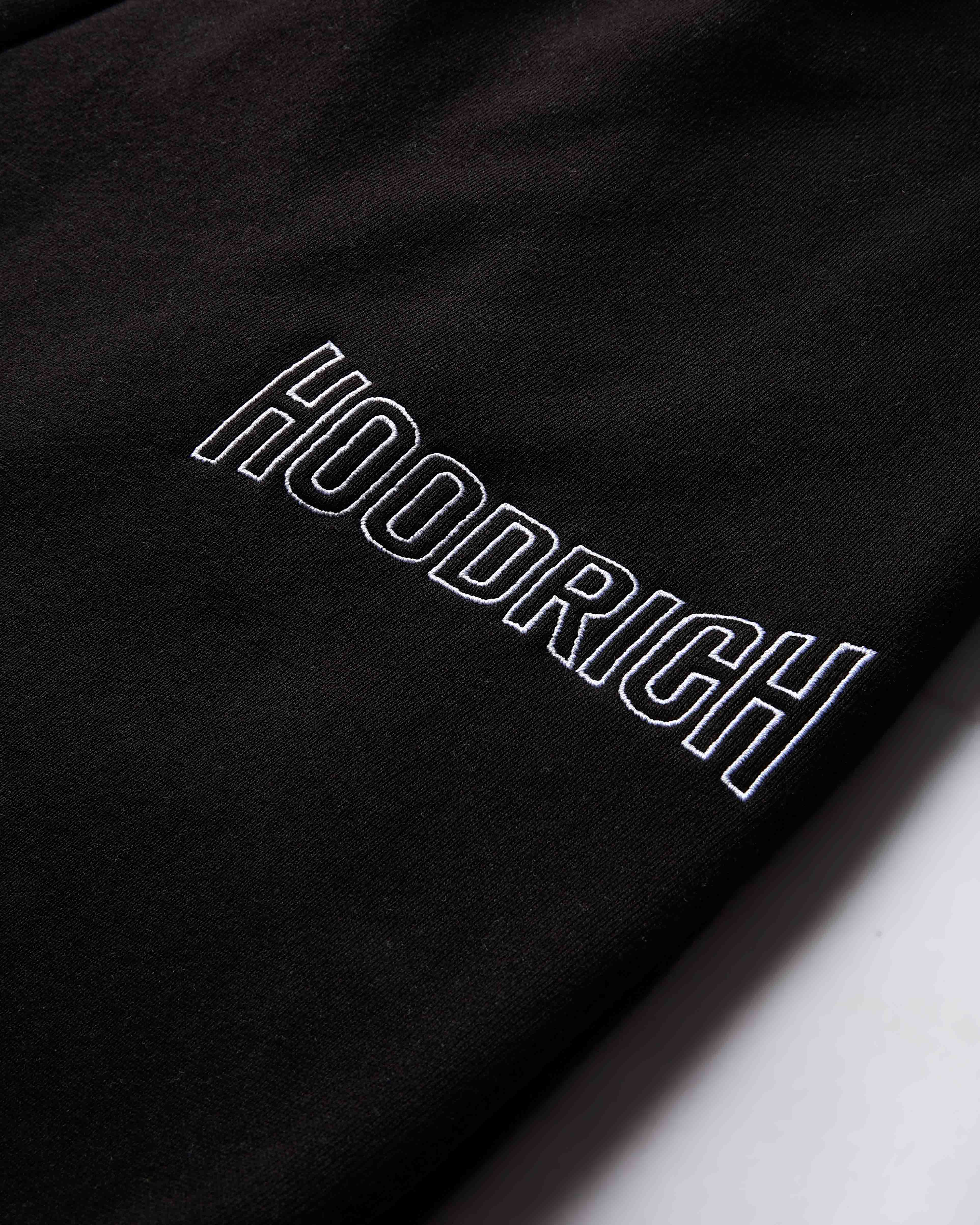 Black fabric with 'HOODRICH' embroidered in white on a white background