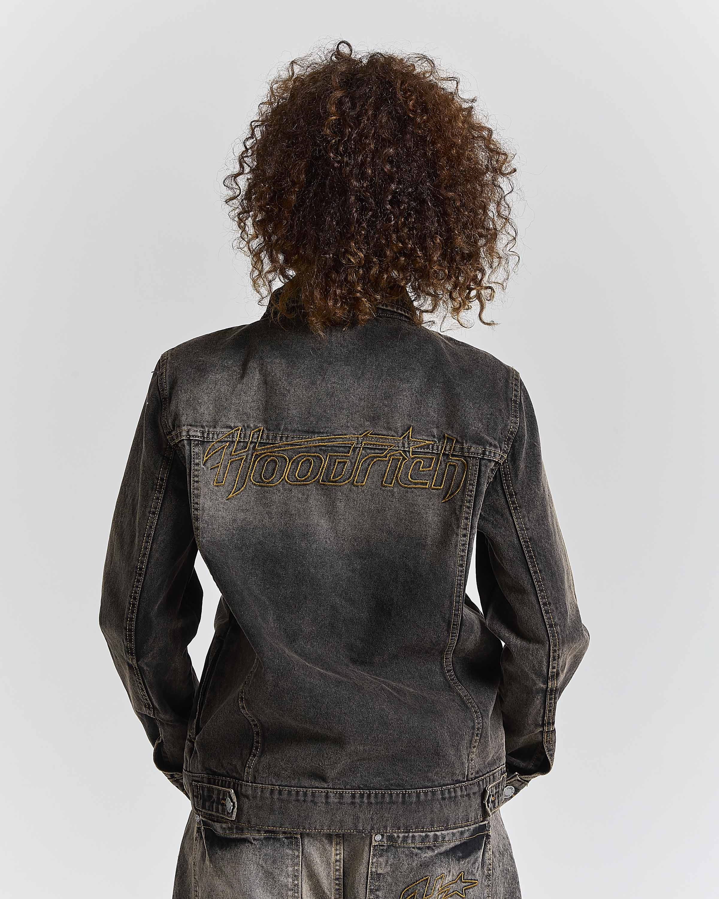 Person wearing a black denim jacket with 'Hoodrich' branding on the back against a white background