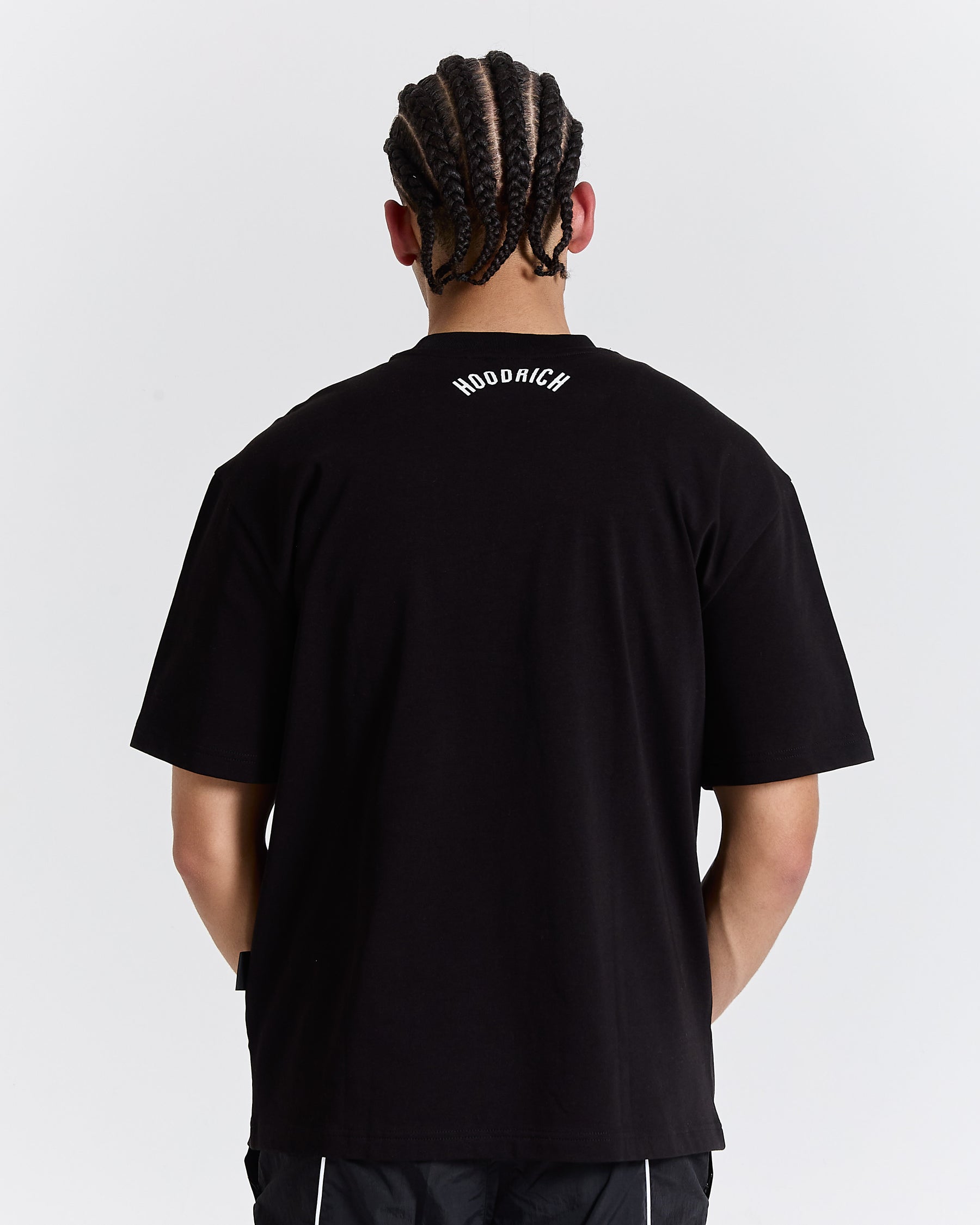 Person wearing a black t-shirt with text on the back against a white background