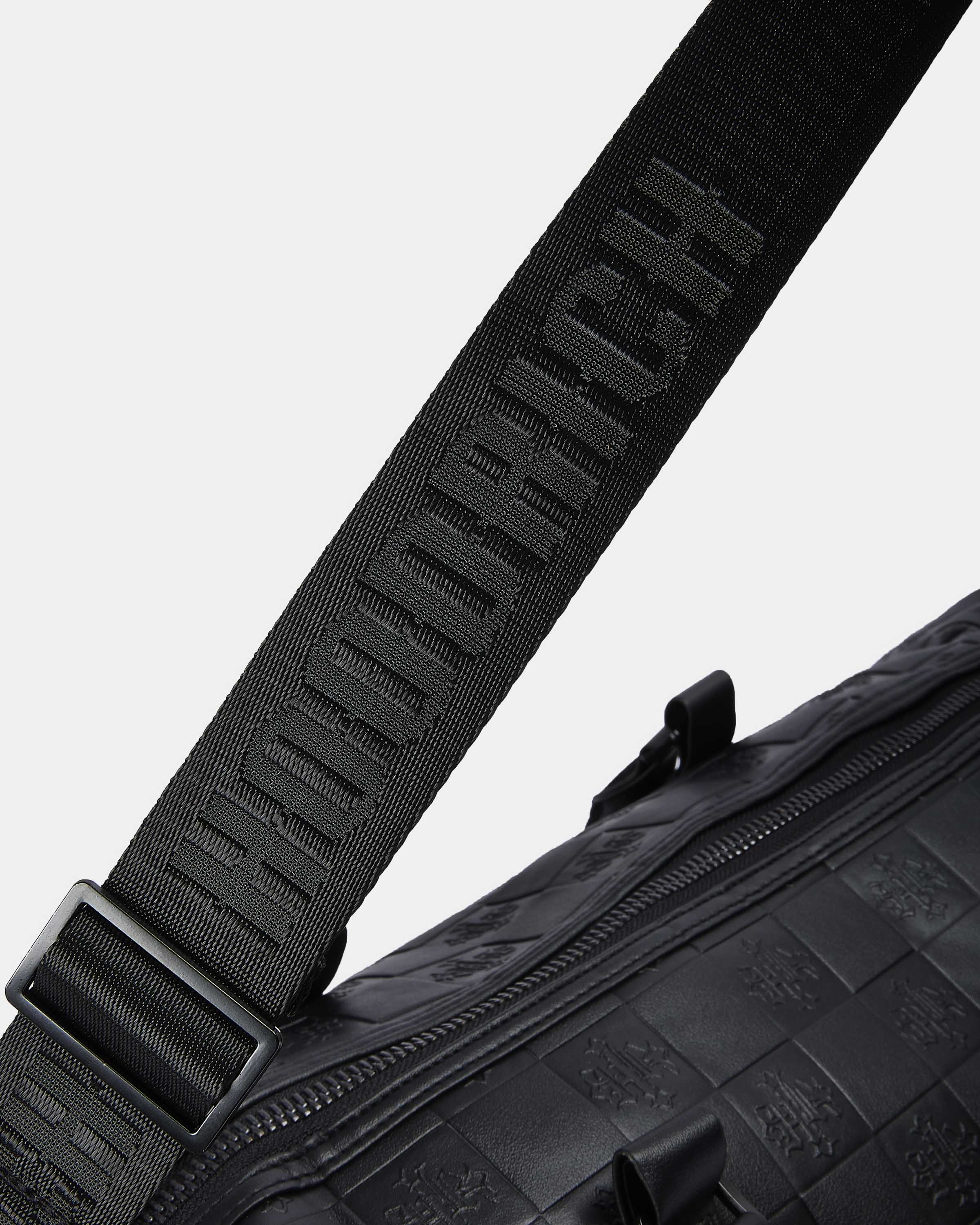Black bag with a strap featuring branding on a light gray background