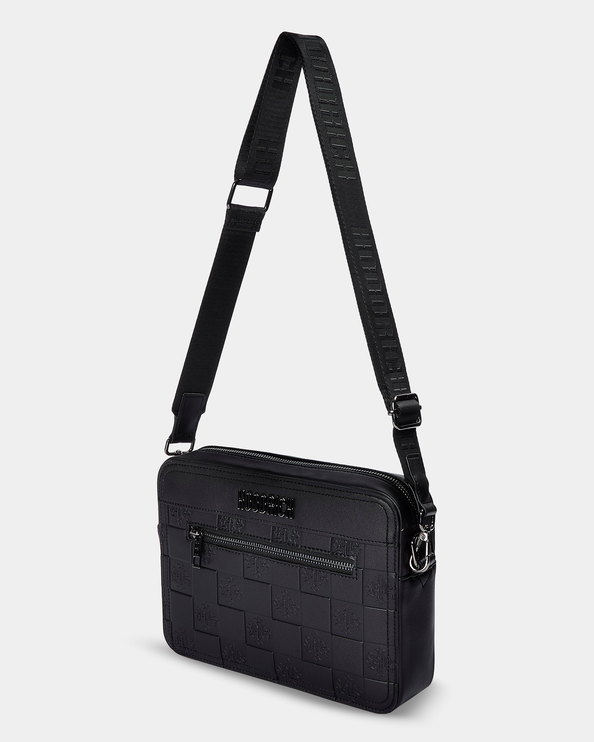 Black crossbody bag with textured pattern on a light gray background