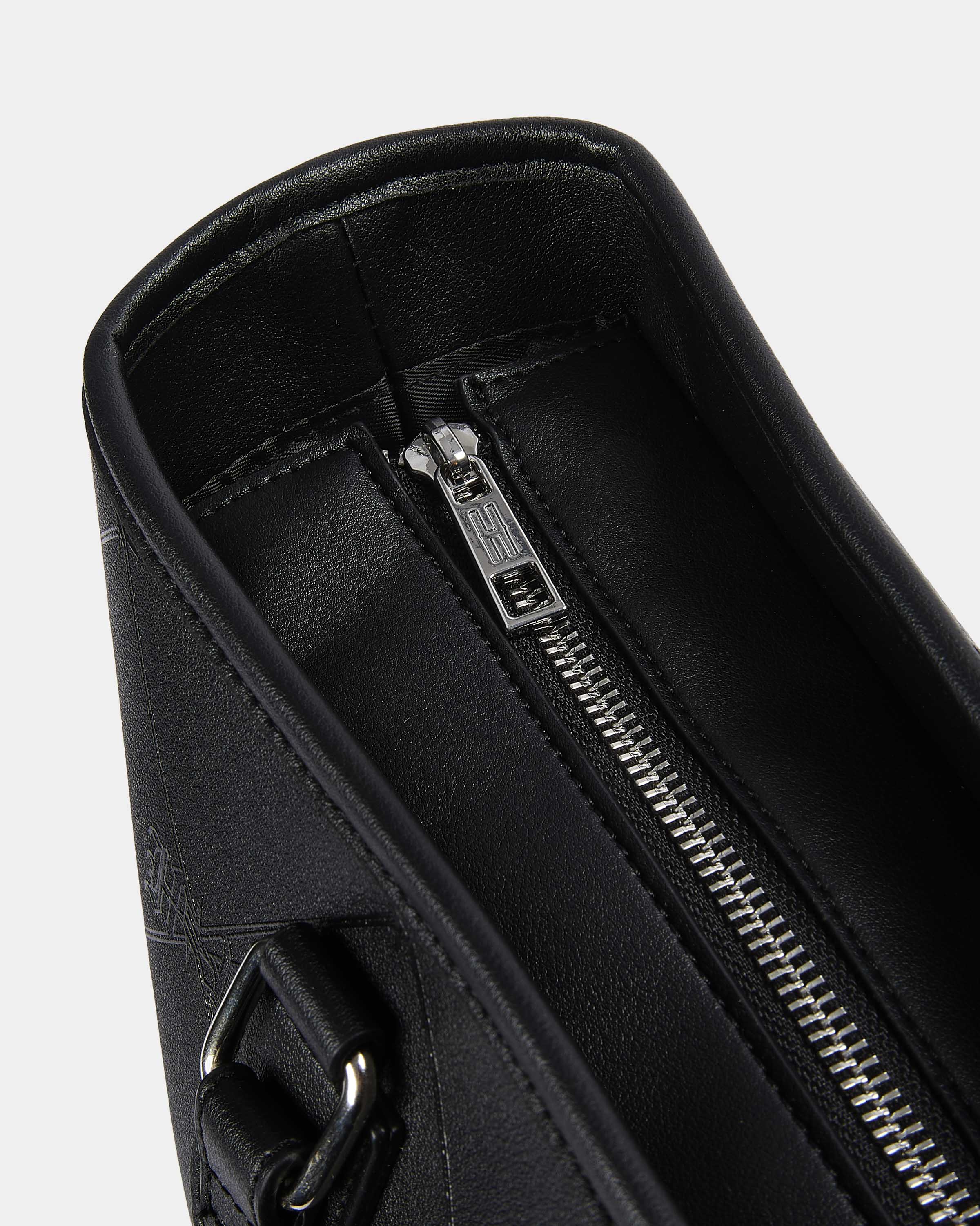 Close-up of a black leather bag with a silver zipper on a light gray background
