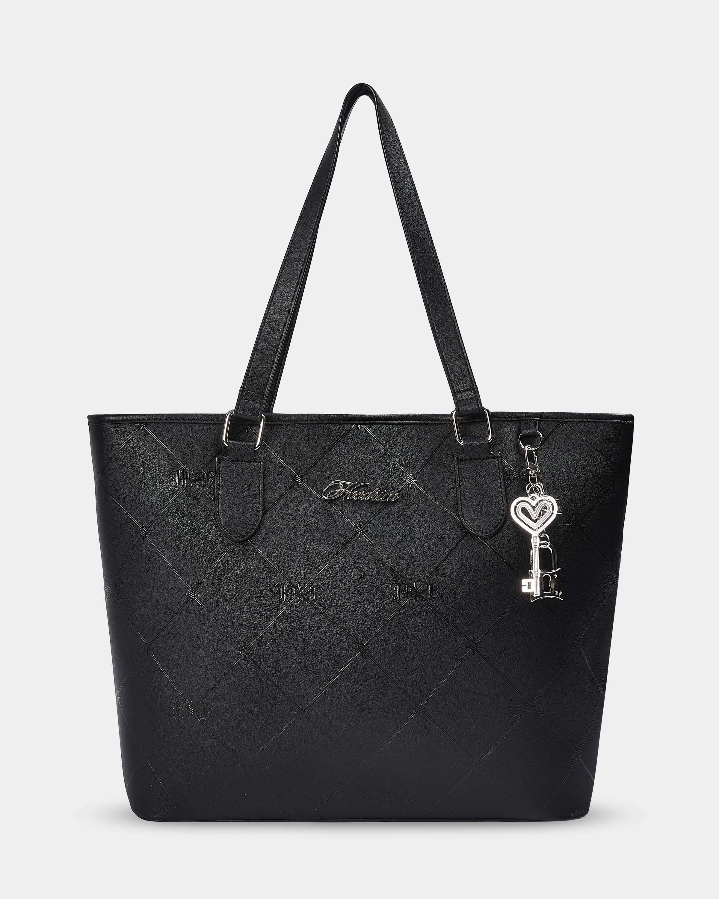 Black quilted handbag with a key-shaped charm on a light gray background