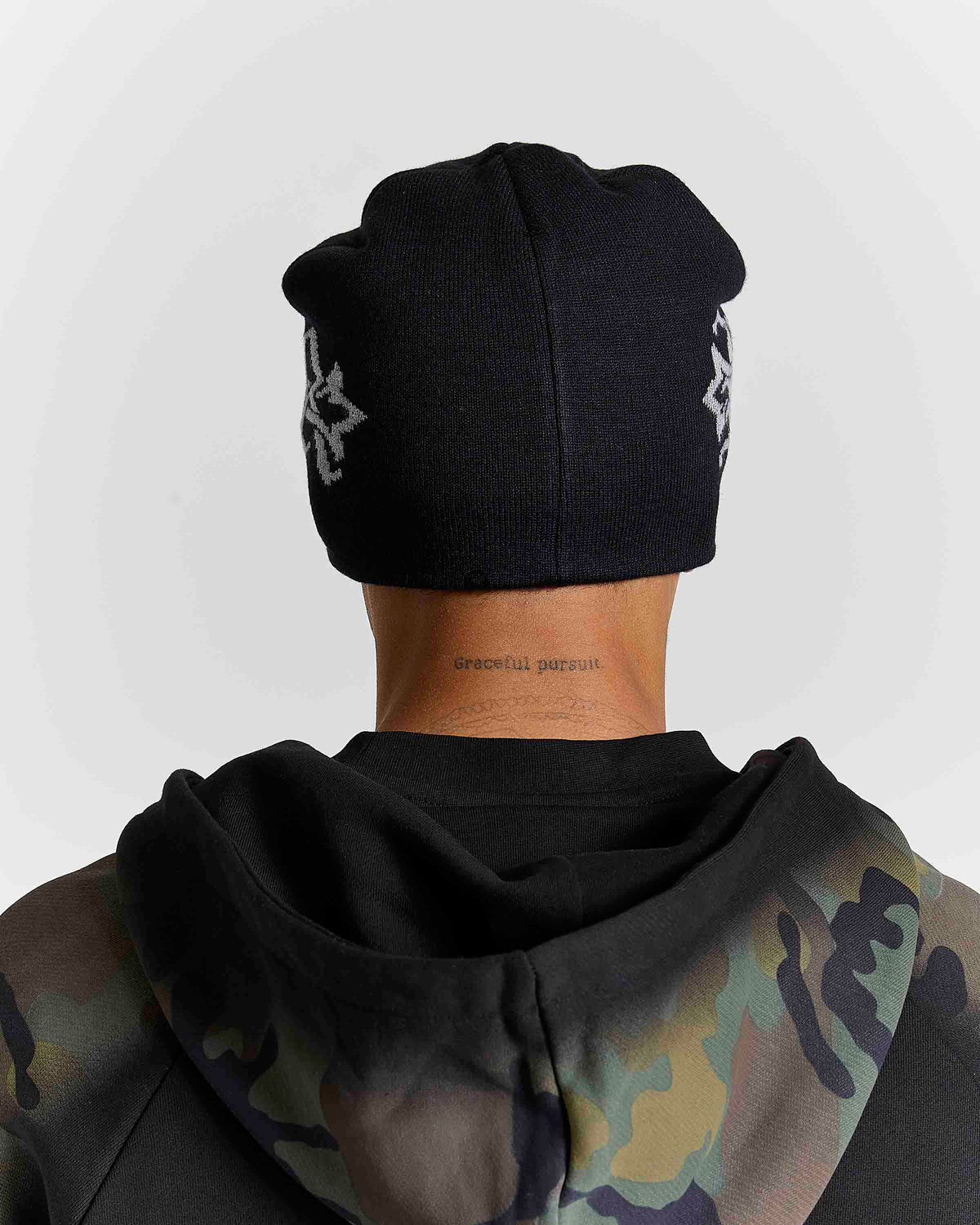 Displays a model wearing the Black & grey 'Hoodrich' branded Virtux Skull Knit Beanie