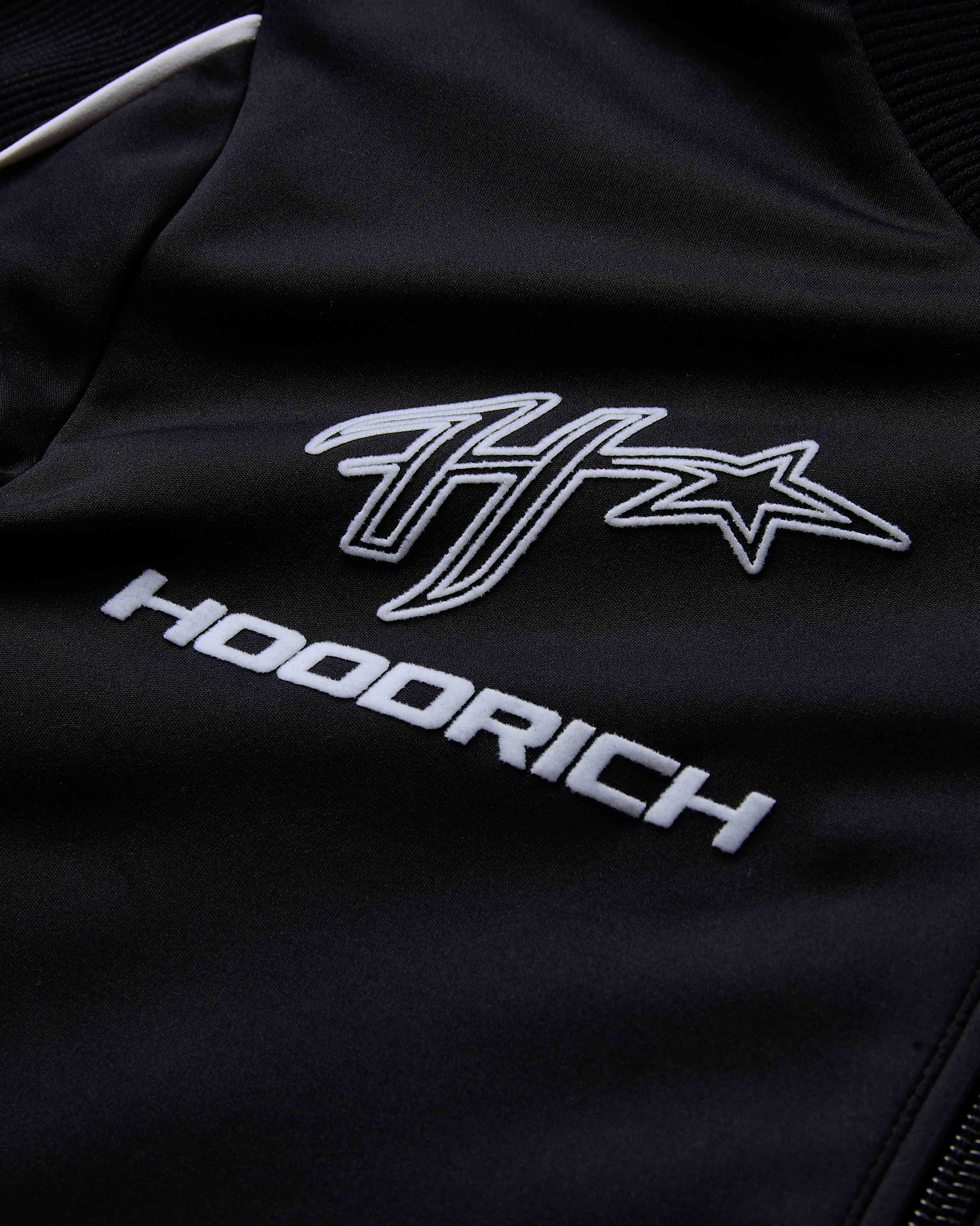 Black jacket with white logo and text on a dark background
