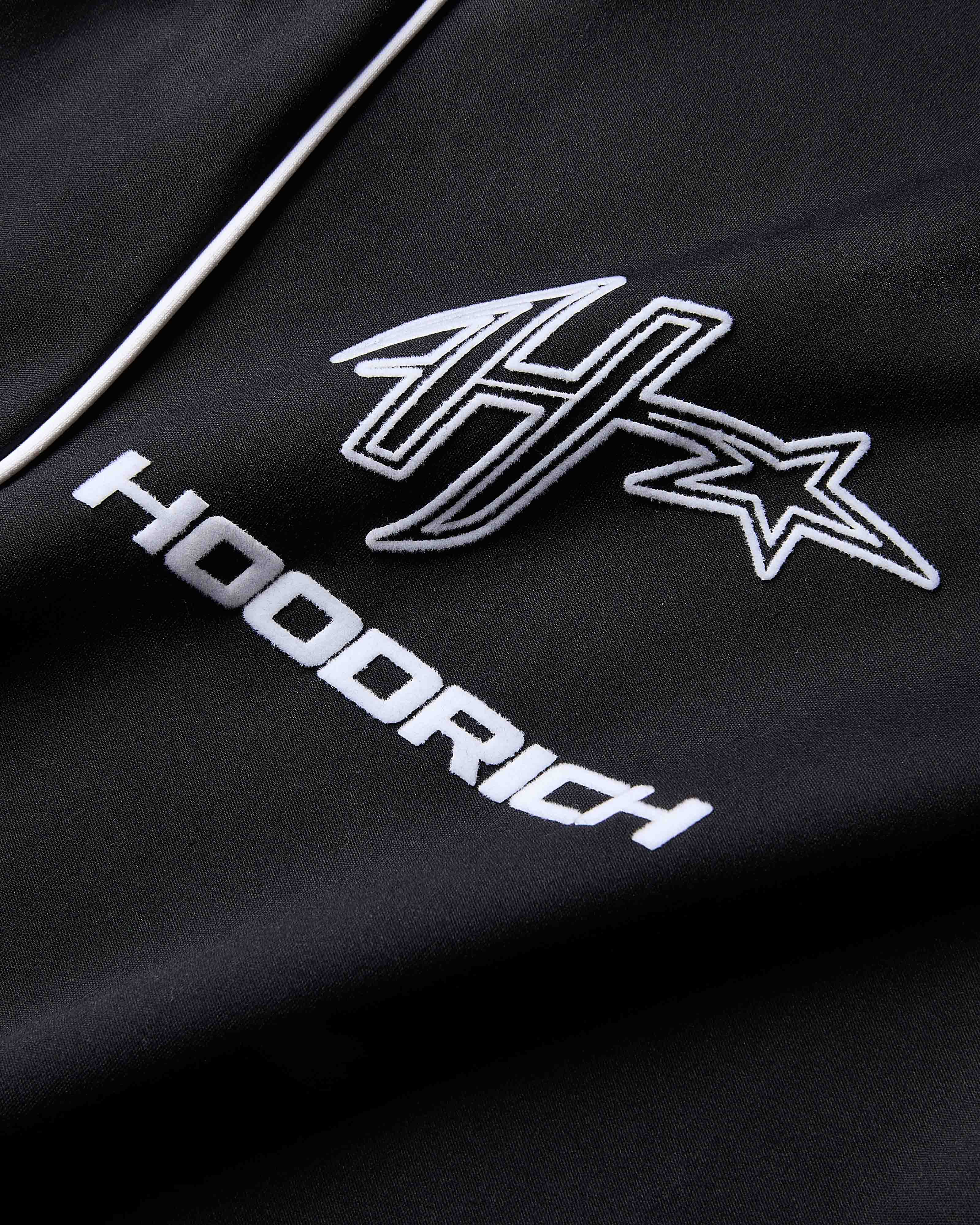 Black hoodie with white logo and text on a dark background