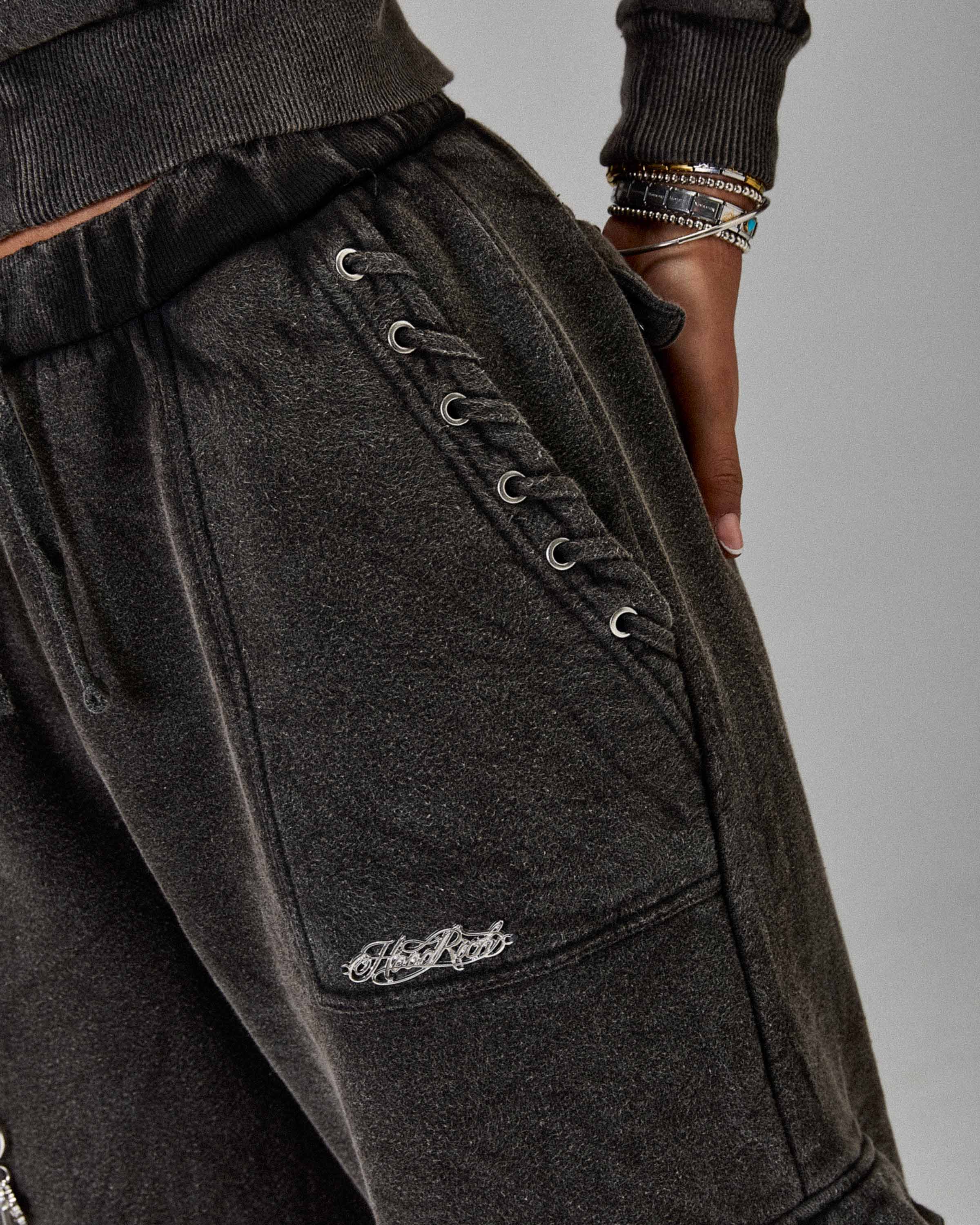 Displays a model wearing the Washed Black 'Hoodrich' branded women's The Winners Circle Token Full Tracksuit