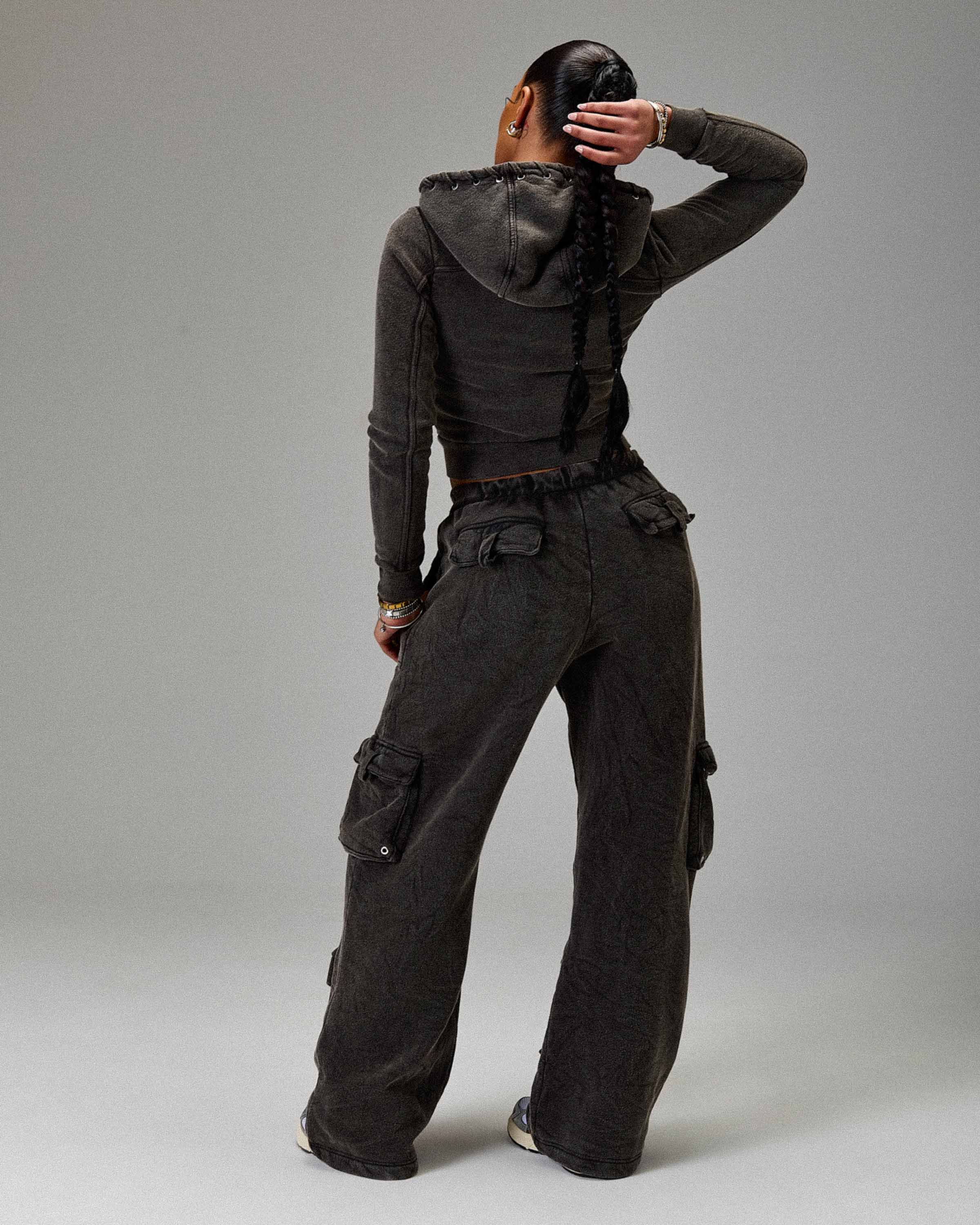 Displays a model wearing the Washed Black 'Hoodrich' branded women's The Winners Circle Token Full Tracksuit