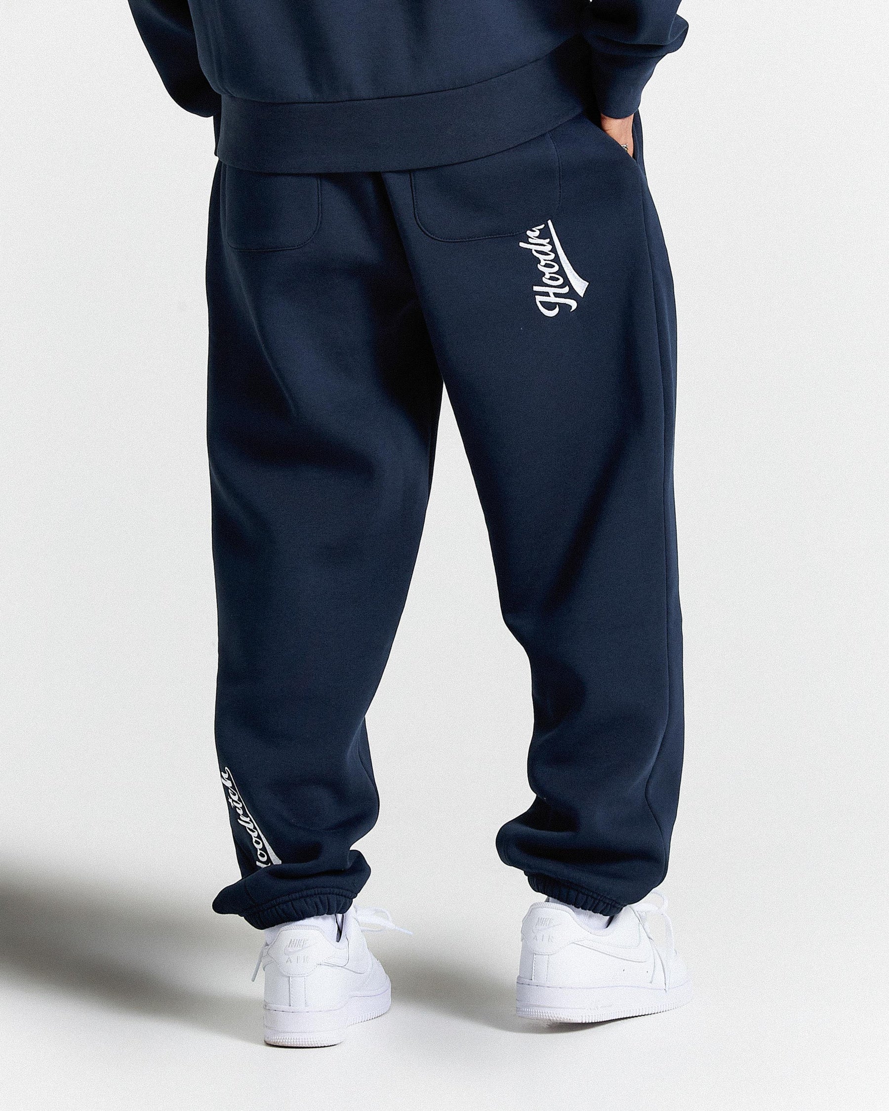 Navy tracksuit with white logo on a light gray background