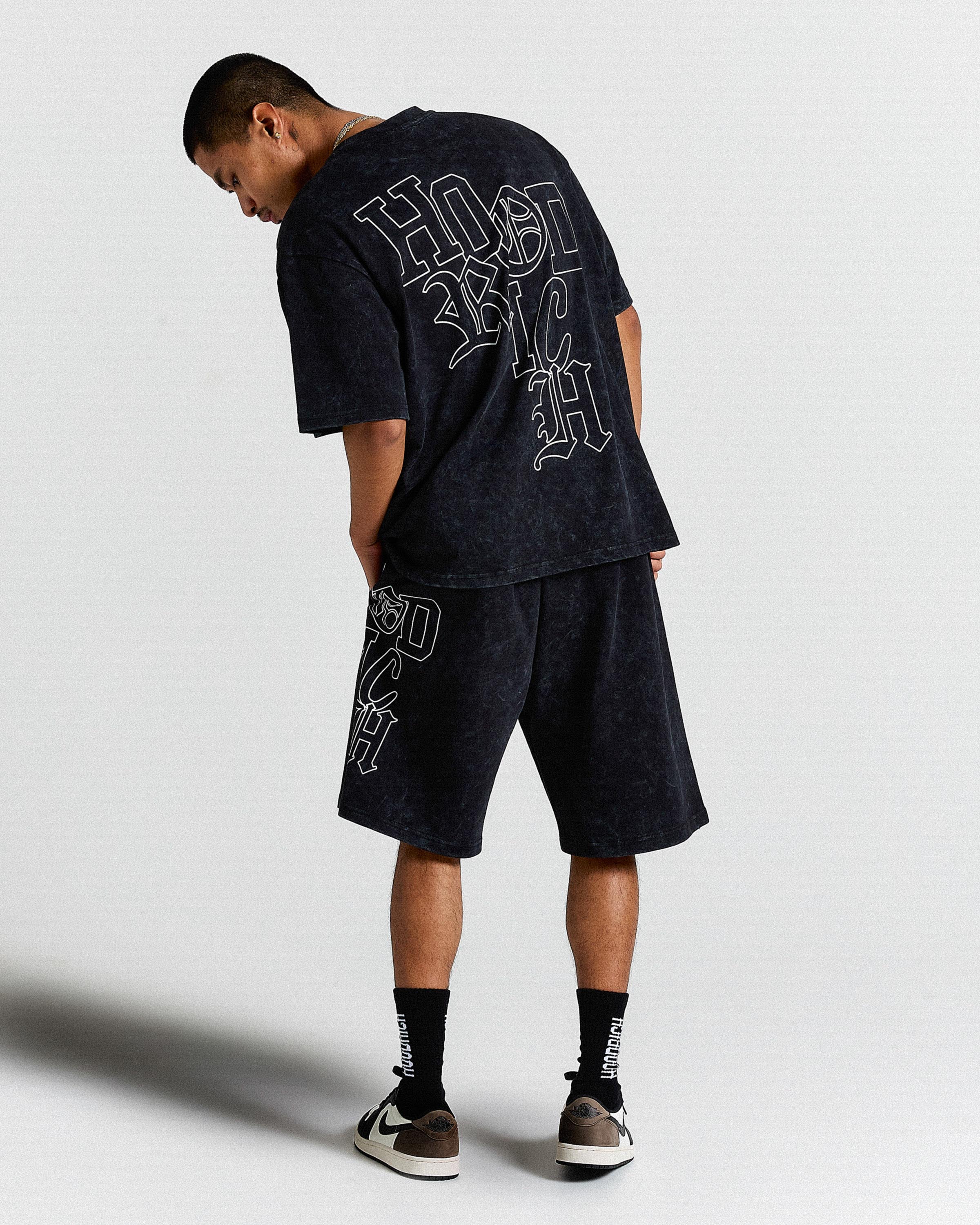 Person wearing a black outfit with white text on a plain background