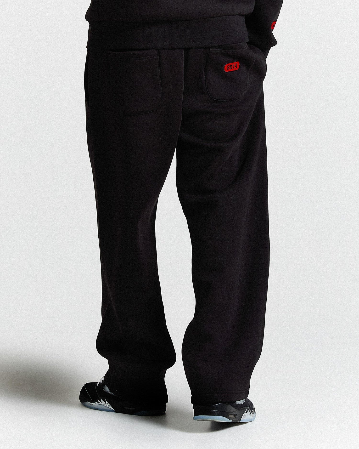 Black pants with a red tag on a white background