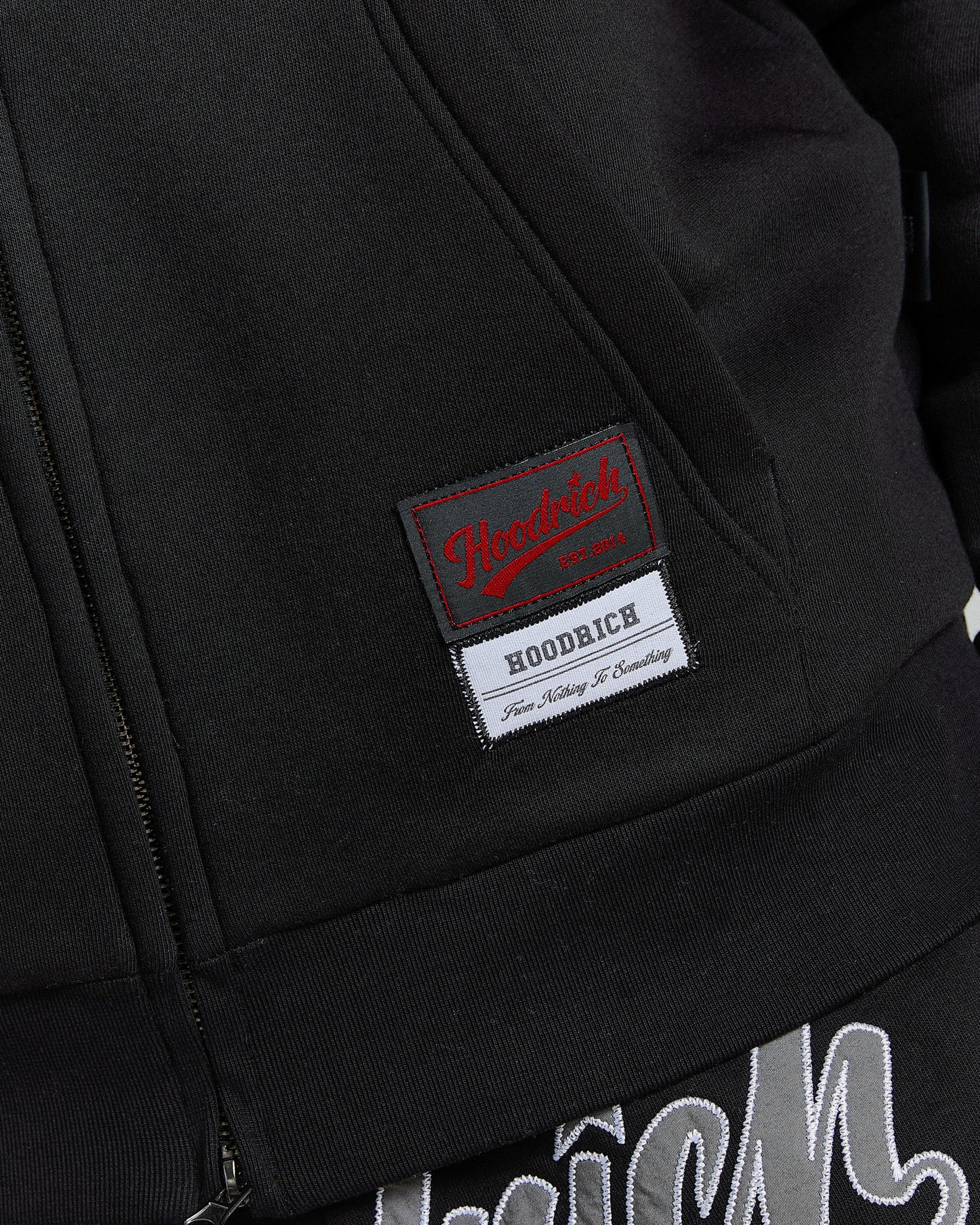 Close-up of a black jacket with a brand label on the pocket.