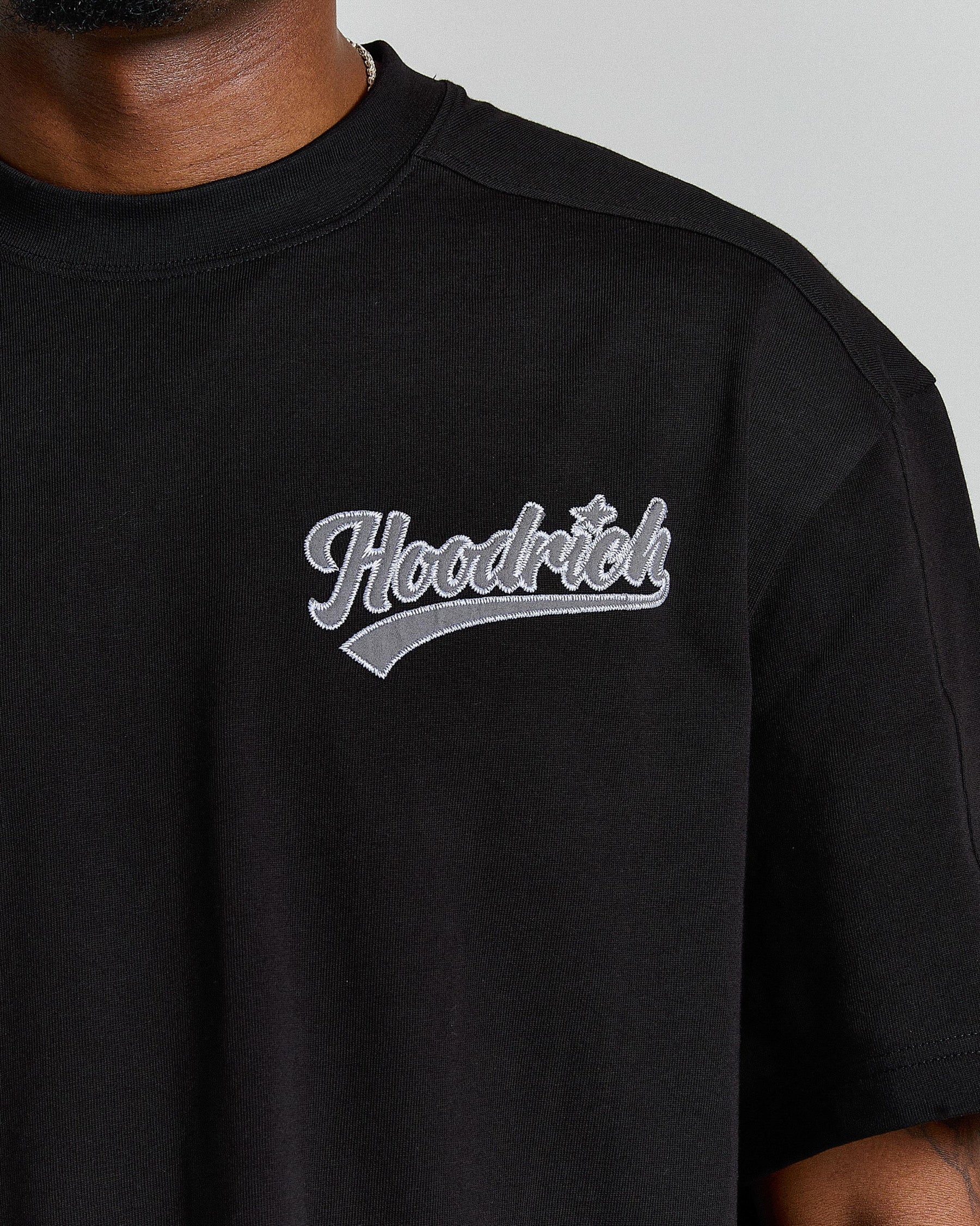 Black t-shirt with 'Hoodrich' logo on a gray background