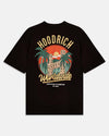 A black short-sleeve t-shirt with a large retro-style graphic on the front. The graphic features the text 'HOODRICH' in arched yellow letters above a circular illustration of a building, palm trees, and a sunset, with 'Worldwide' written in yellow script below.