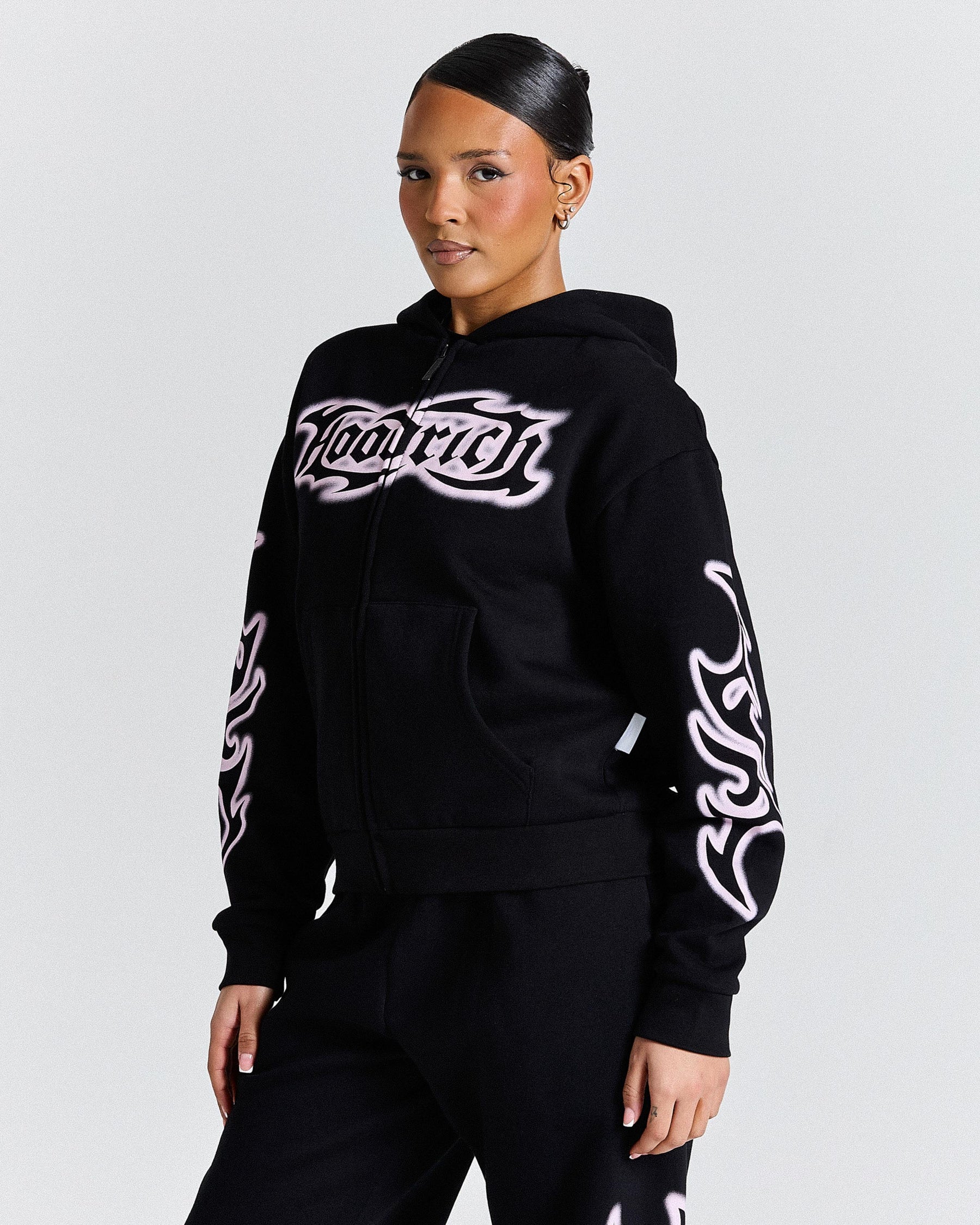 Person wearing a black hoodie with white designs and text on a gray background