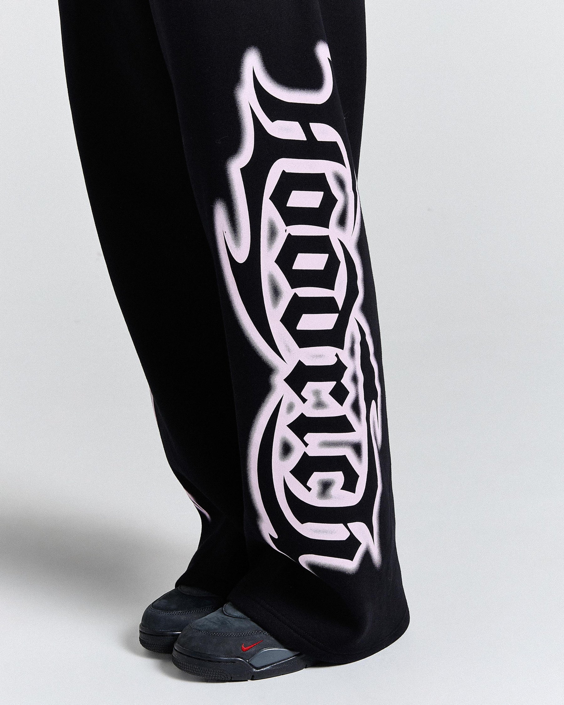 Black pants with white tribal design on a light gray background