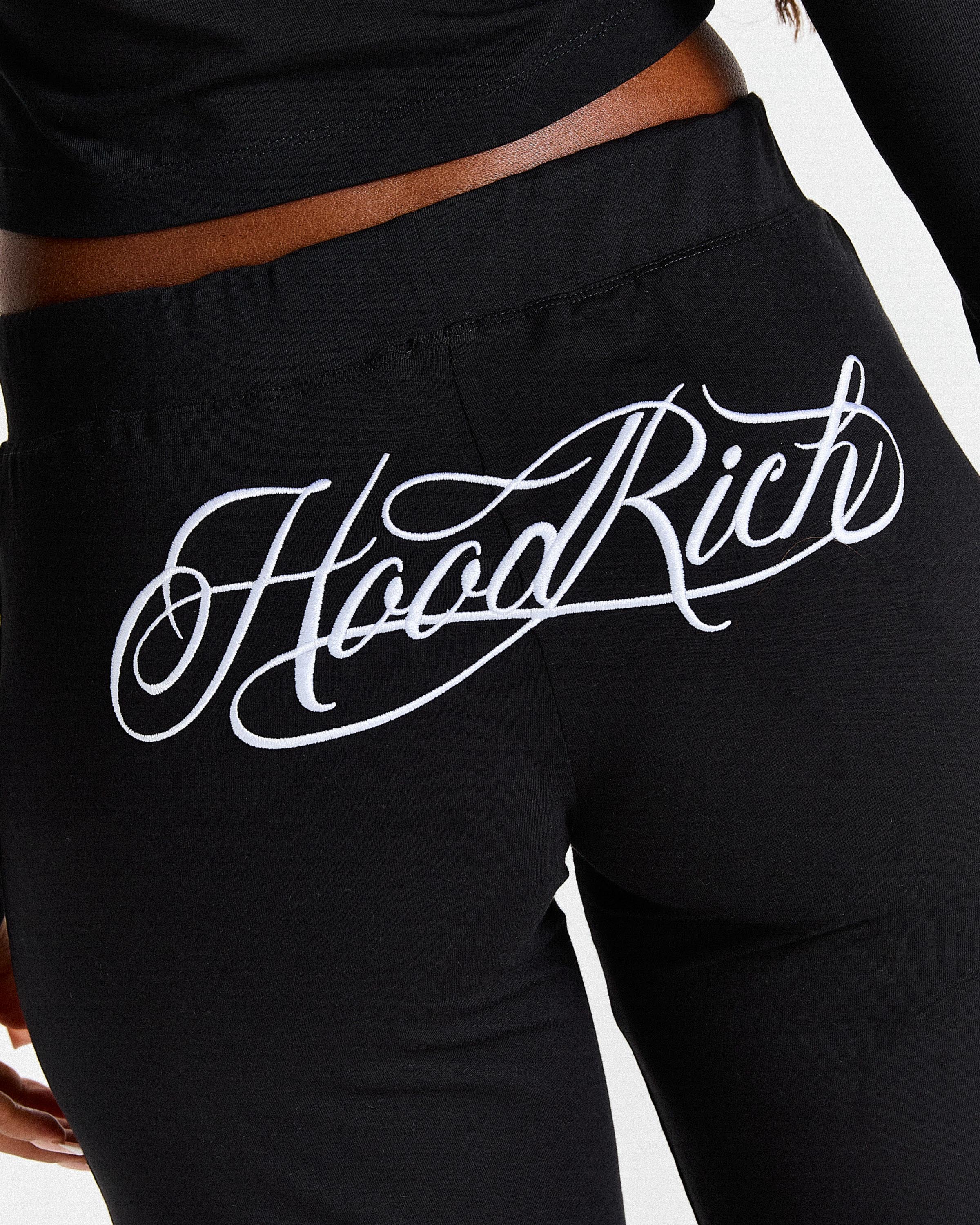 Black pants with 'Hood Rich' text on a white background