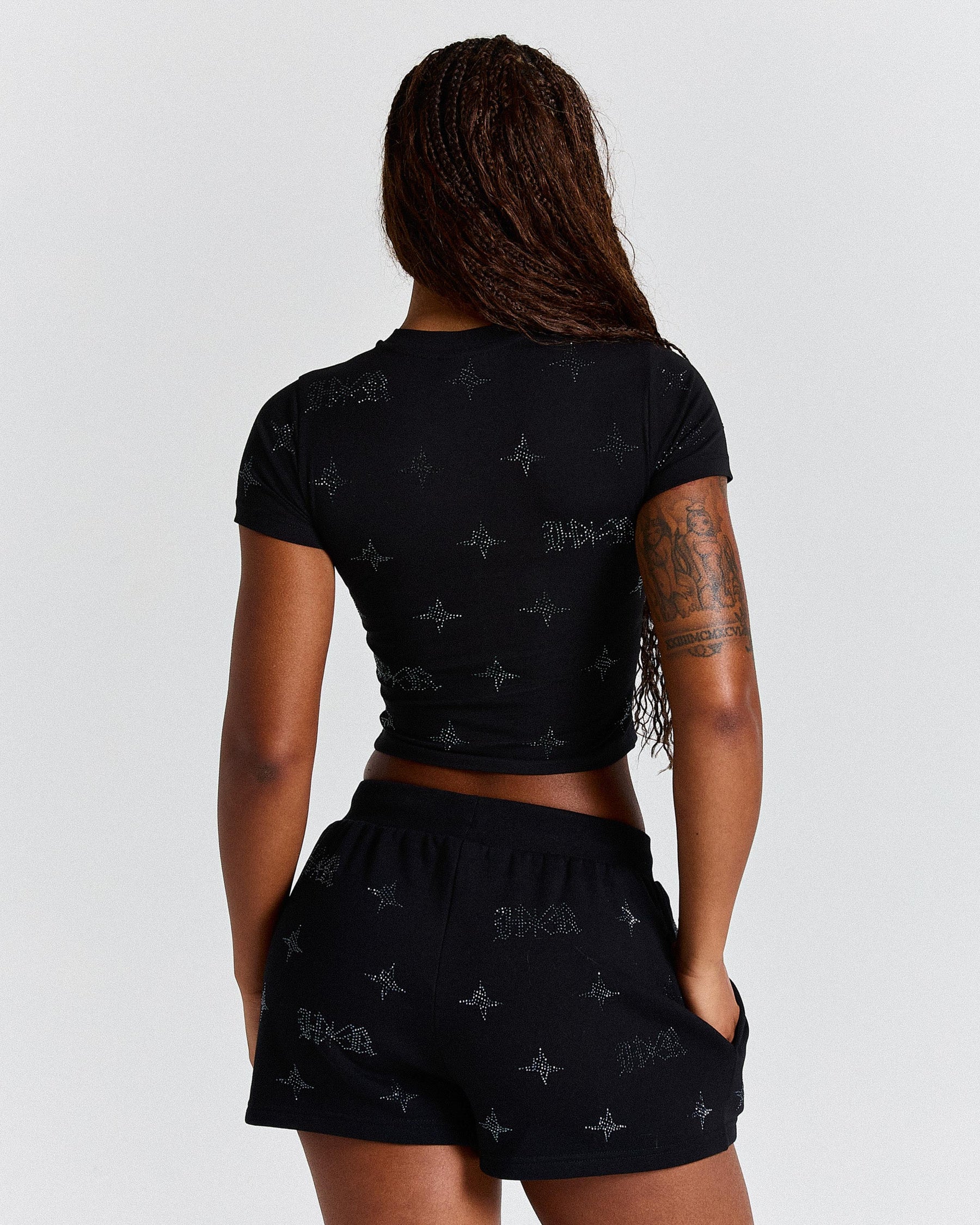 Person wearing a black t-shirt and shorts set with a pattern on a white background