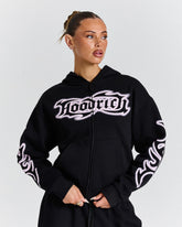 Person wearing a black hoodie with white branding on a light gray background