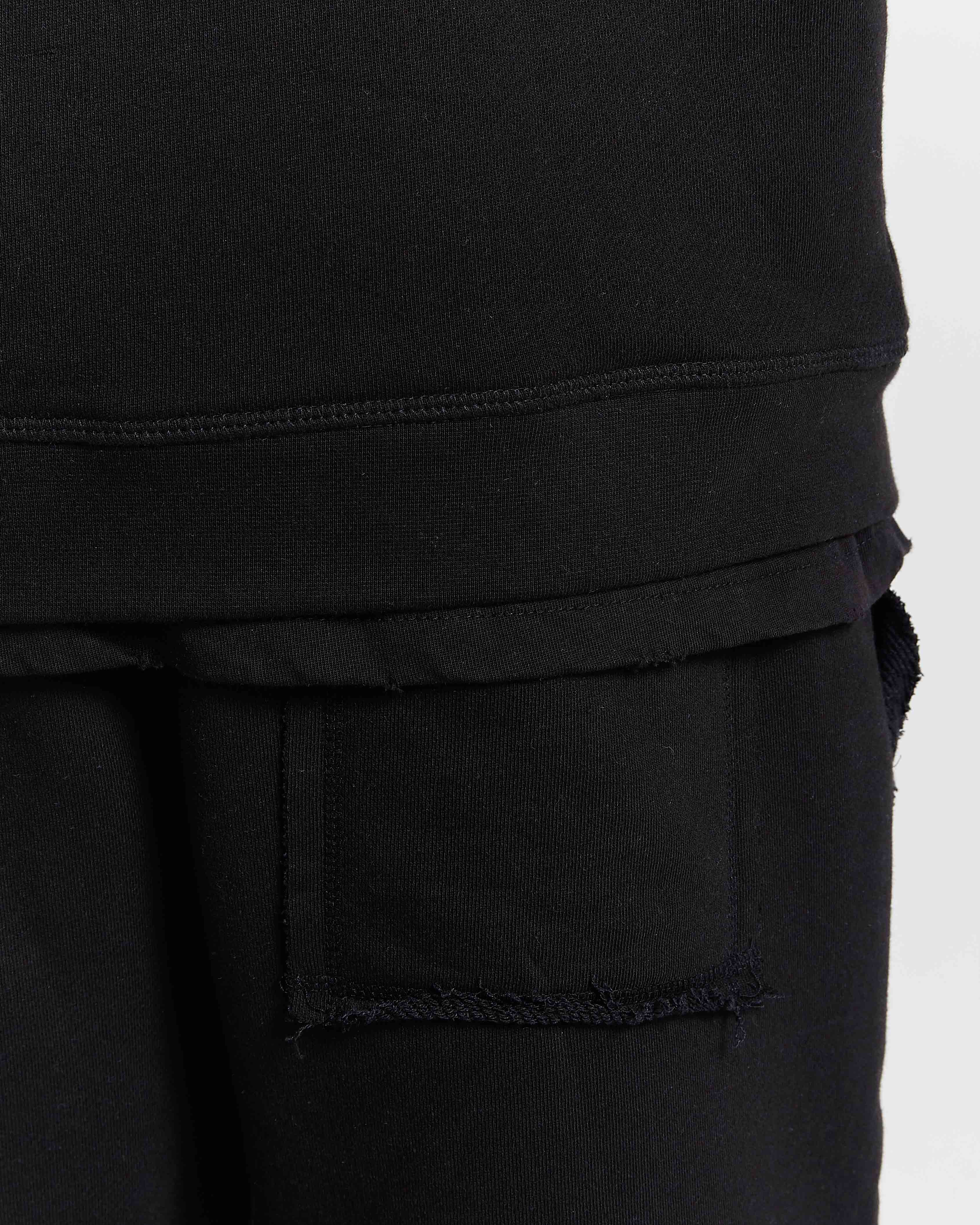 Close-up of black pants with a pocket on a white background