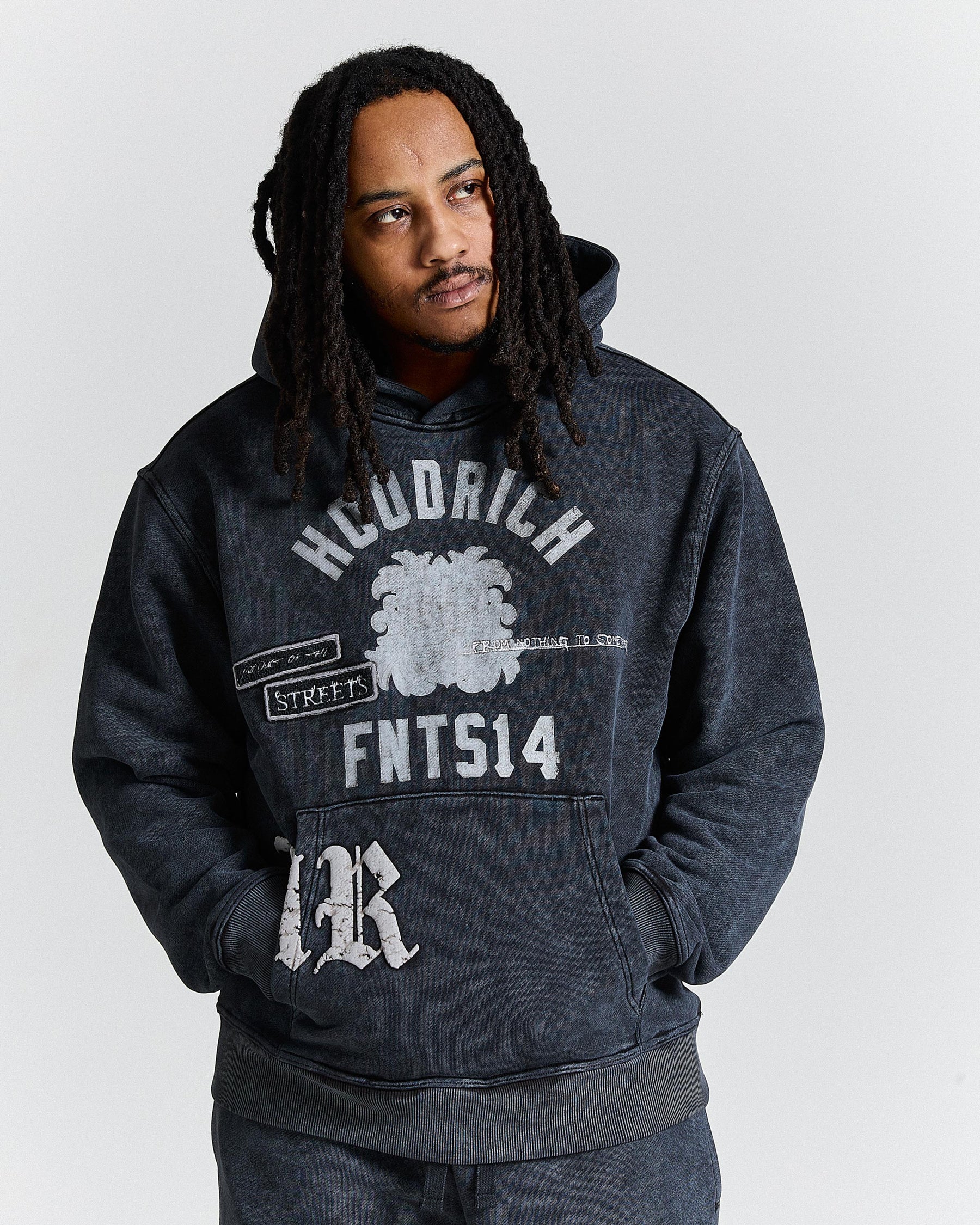 Person wearing a dark hoodie with text and graphics on a white background