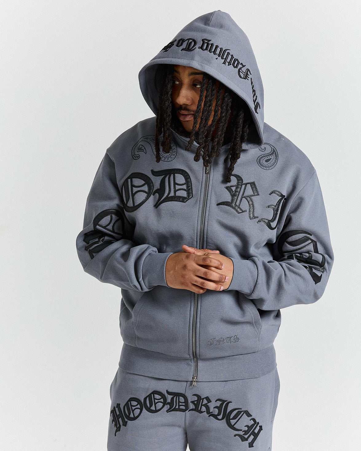 Person wearing a gray hoodie with branding on a white background