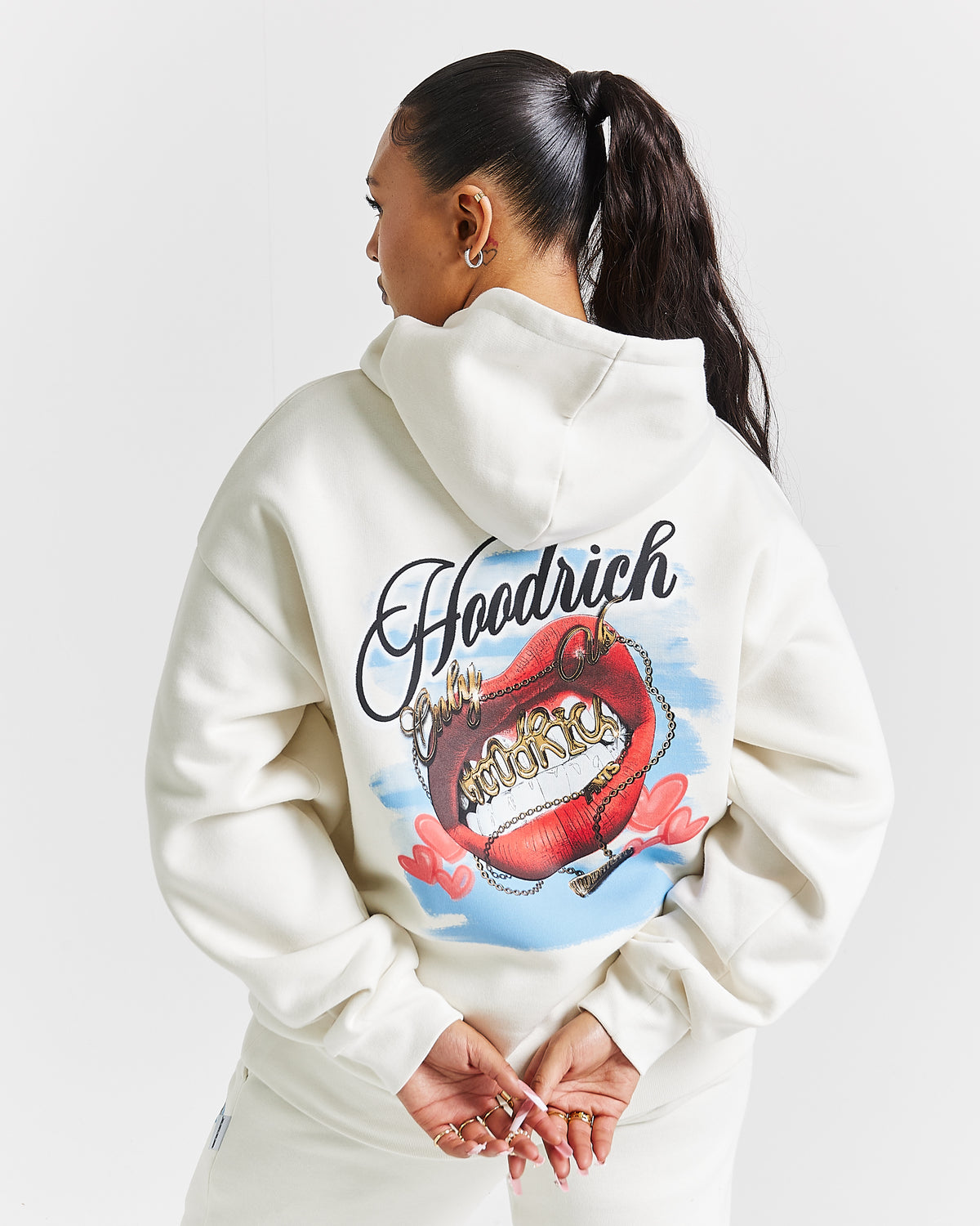 Displays a model wearing the White 'Hoodrich' branded women's Grillz Full Tracksuit 