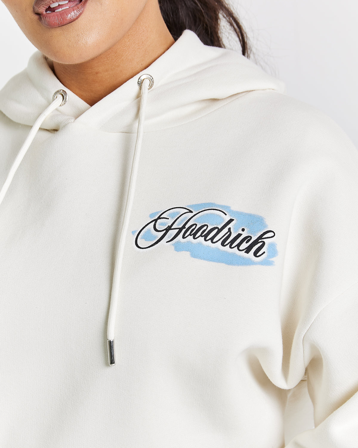 Displays a model wearing the White 'Hoodrich' branded women's Grillz Full Tracksuit featuring the details on the brading 