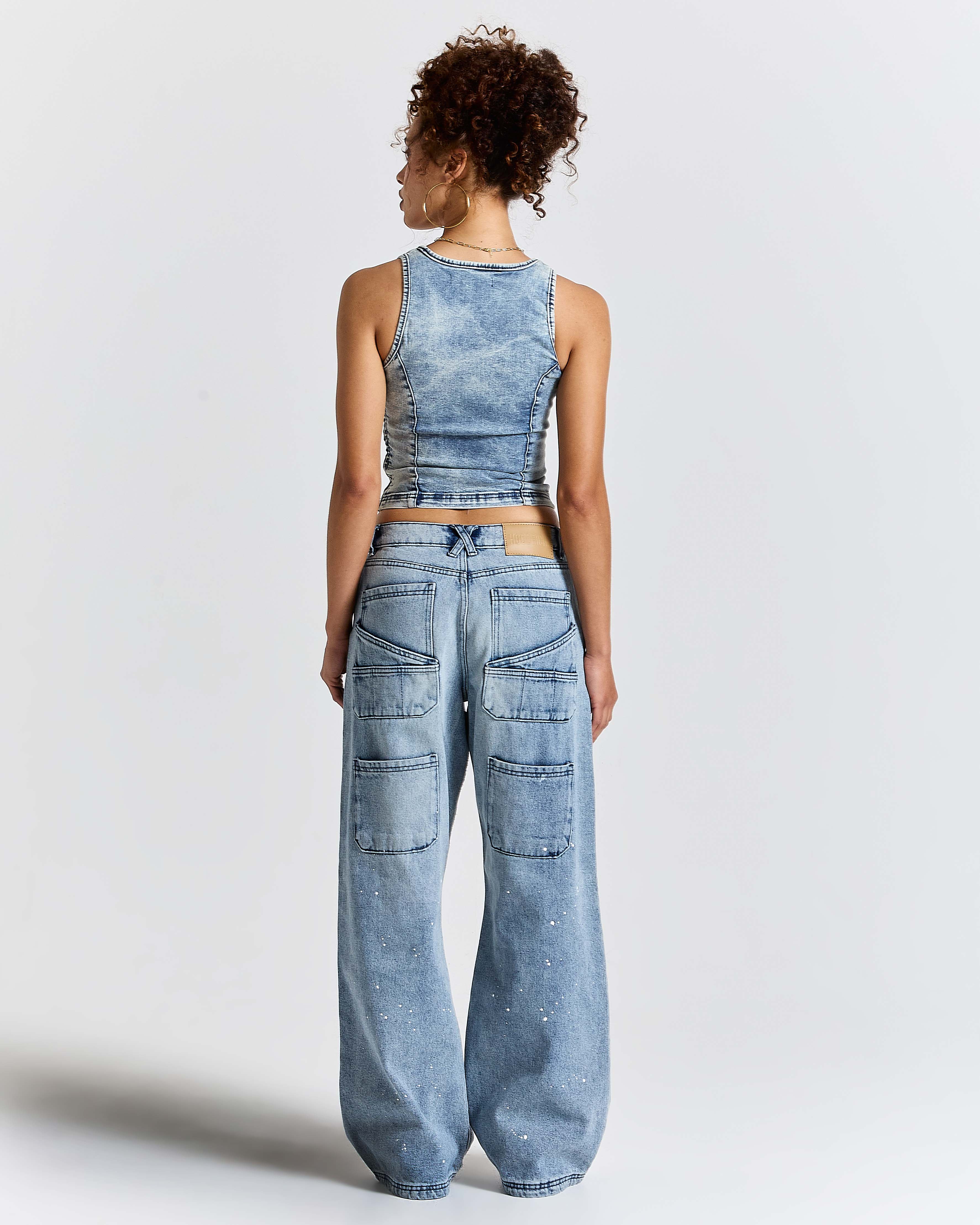 Person wearing a denim outfit with a matching top and pants on a white background